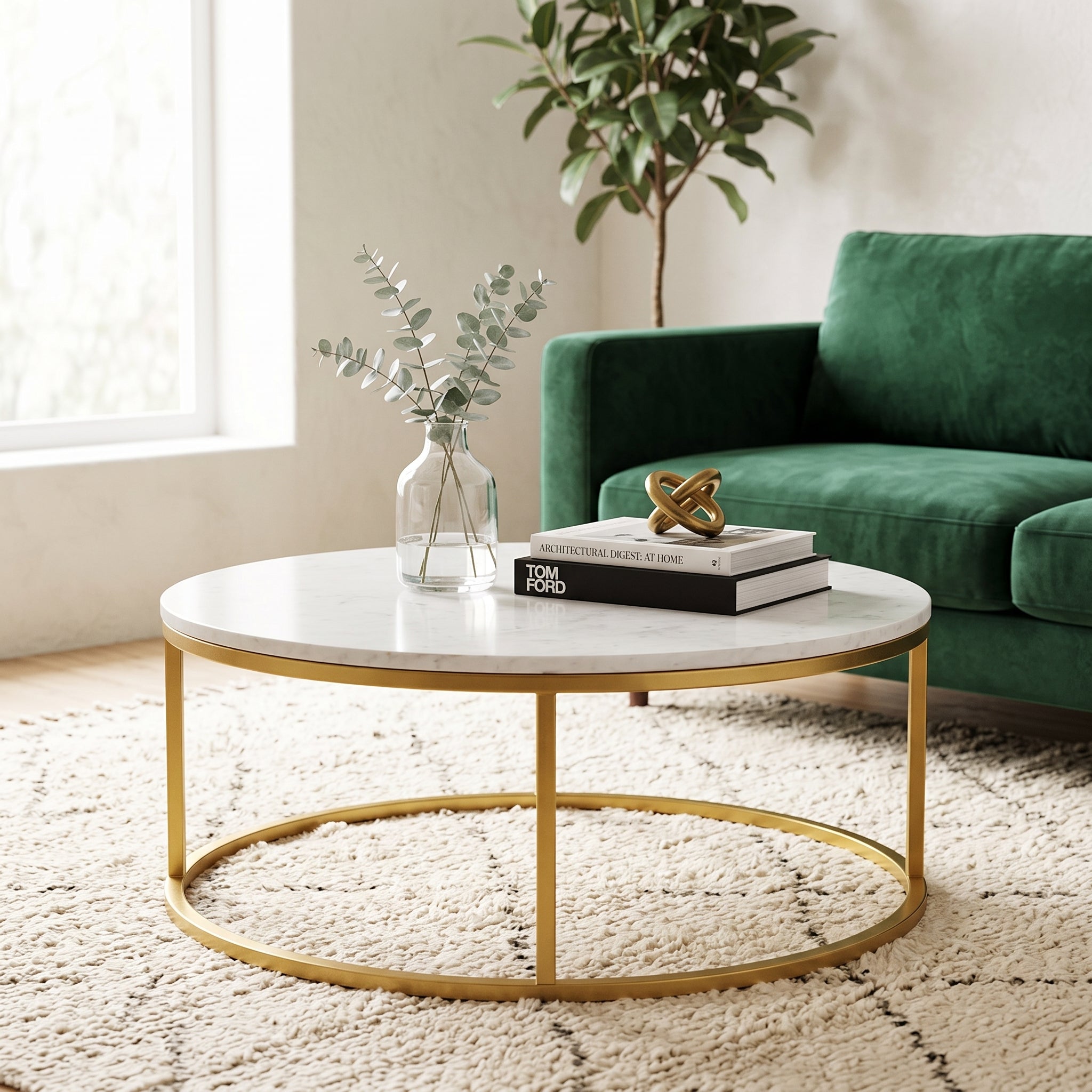 Lifestyle view of round white marble coffee table with gold frame on patterned rug near window